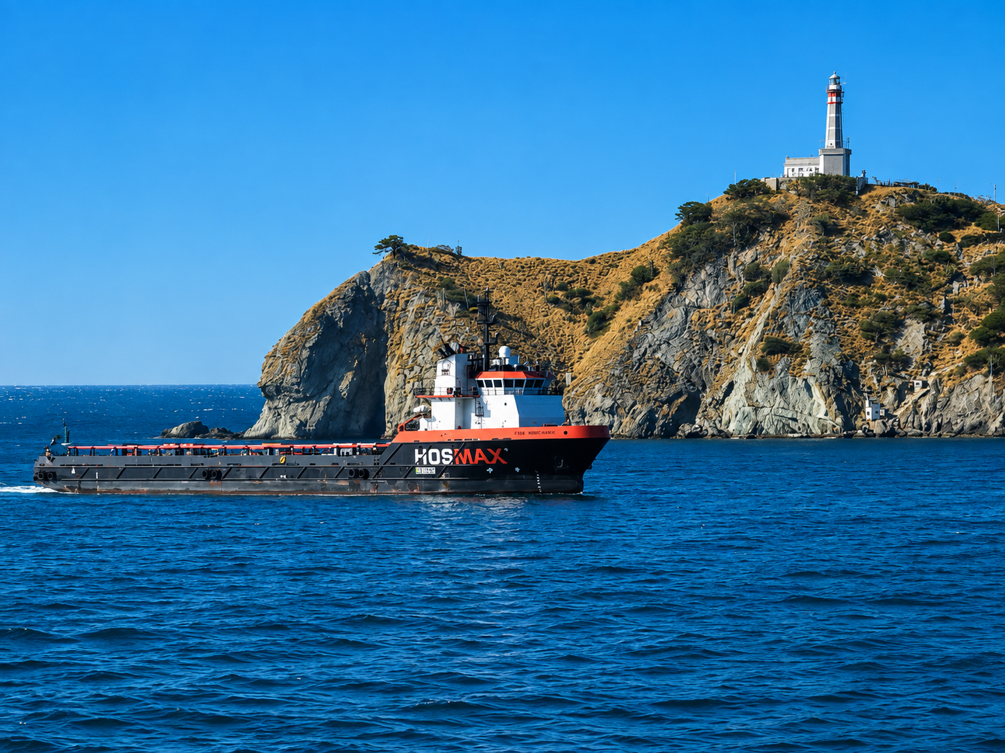 Offshore support vessel passing a coastal cliff