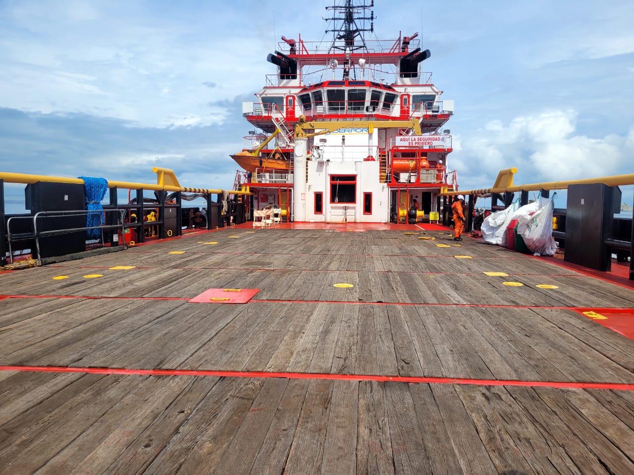 Deck crew working under a safety-first sign aboard an offshore support vessel