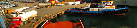Port operations with tanker trucks and tugboat